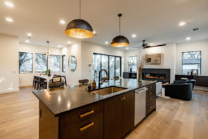 Open plan living, dining and kitchen at 2007 De Verne custom home with European white oak floors and four part sliding door to patio