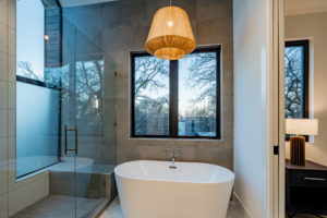 Soaking tub and curbless shower with designer window package at Zilker custom home
