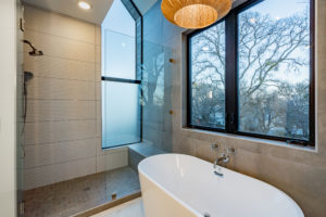 Walk in shower with designer tiler and soaking tub at Zilker custom home