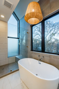 Walk in shower with designer tile and soaking tub at Zilker custom home